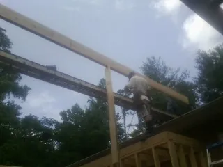 Carpenter setting a ridge beam over a new addition frame — Ice Dam Removal by Roofing Brothers in Wilmerding