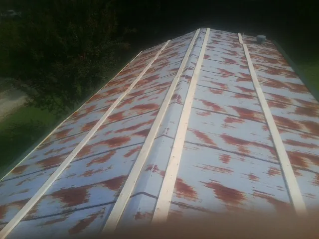 Rusted metal roof panels with new wood purlins before replacement — Storm Damage Roof Repair in Wilmerding by Roofing Brothers