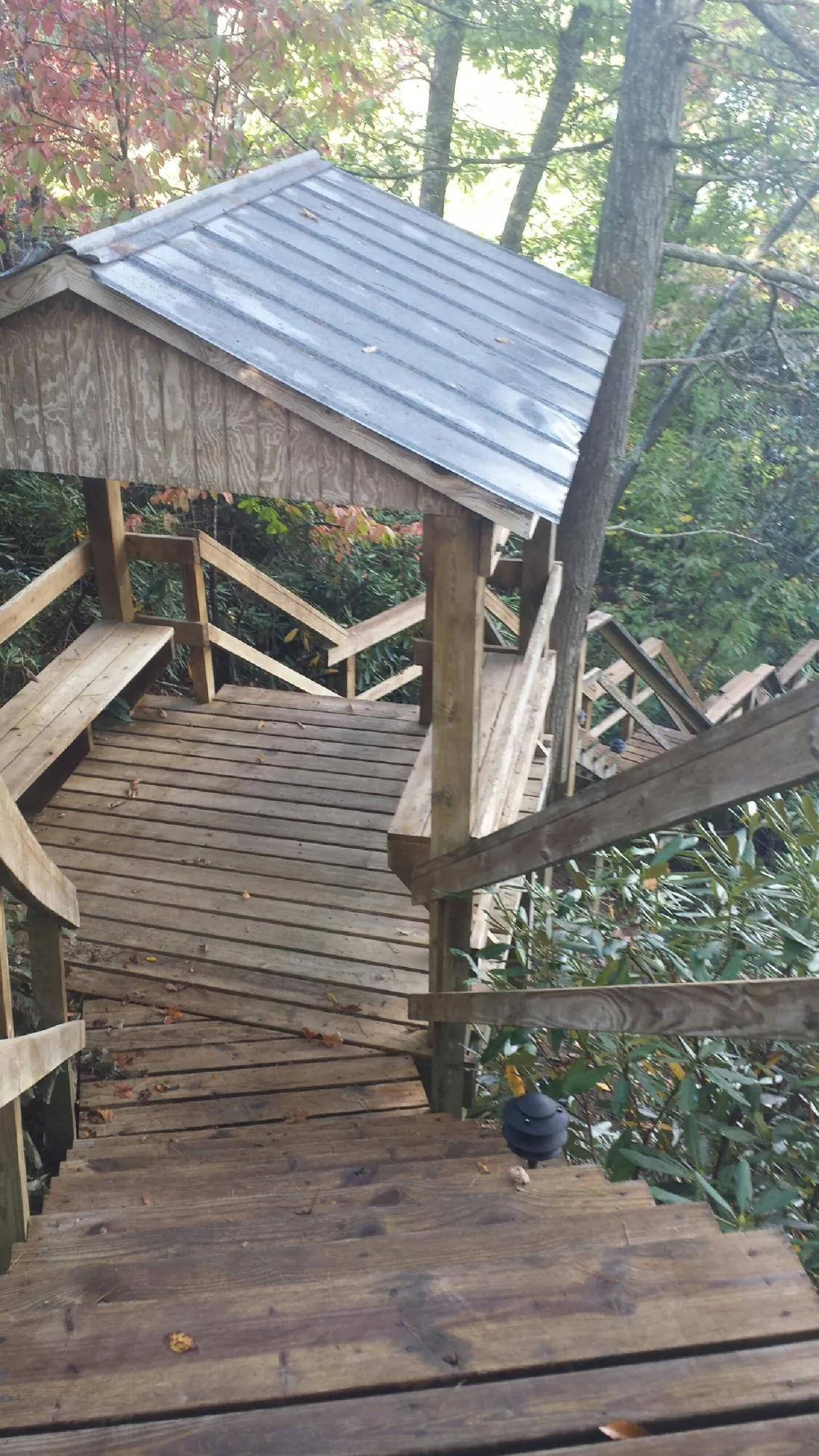 Metal roofed shelter over wooden steps on a wooded walkway — Skylight Repair & Installation work by our crew in Wilmerding