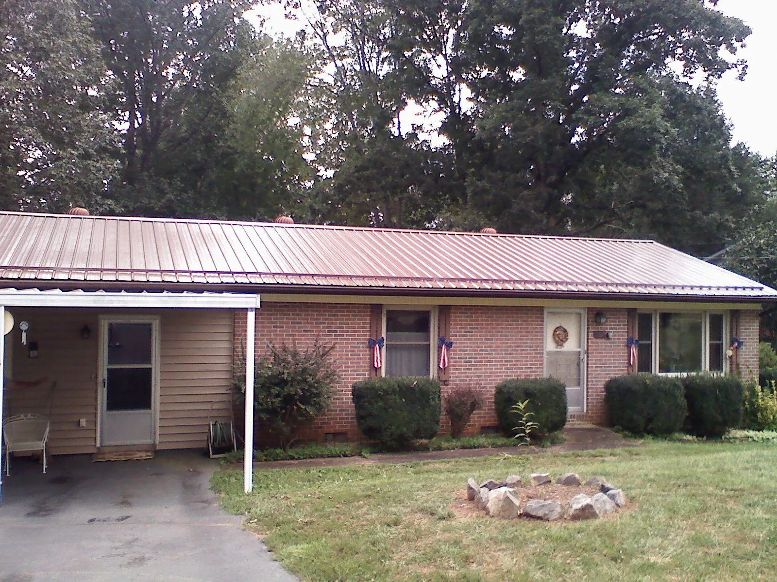 Bronze metal roof and carport on a brick ranch home — Roof Repair work by our crew in Wilmerding