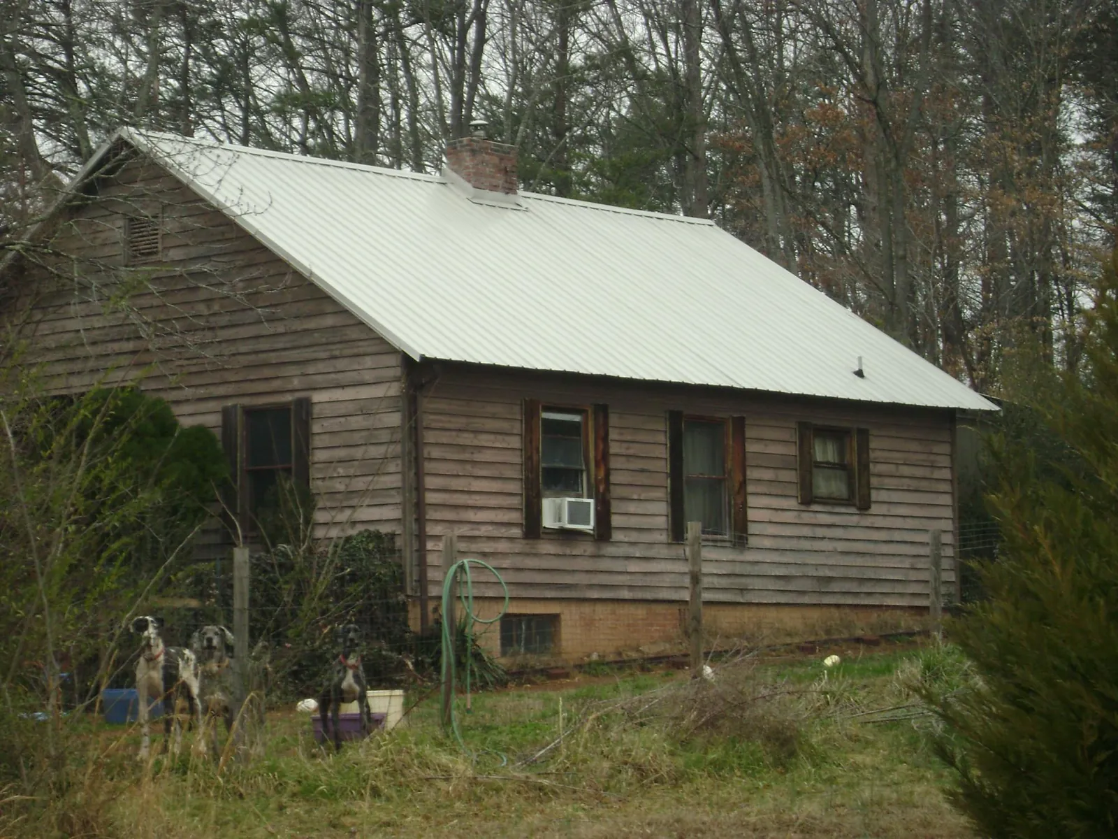 White metal roof on an old wood sided farmhouse, from a Metal Roof Installation job in Wilmerding